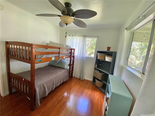 bedroom with wood finished floors, ceiling fan, and baseboards
