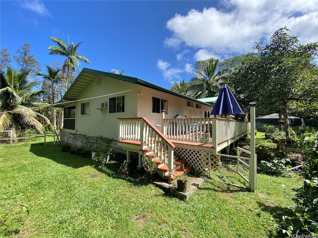 rear view of house featuring a lawn and a wooden deck