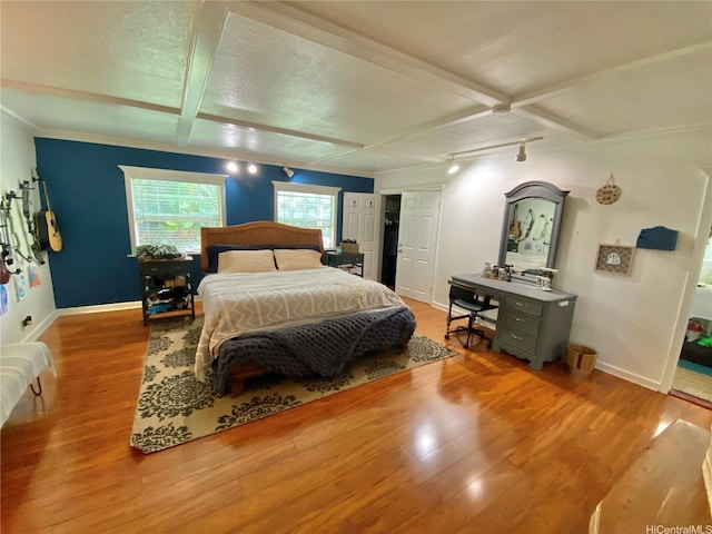 bedroom featuring wood finished floors, baseboards, and crown molding