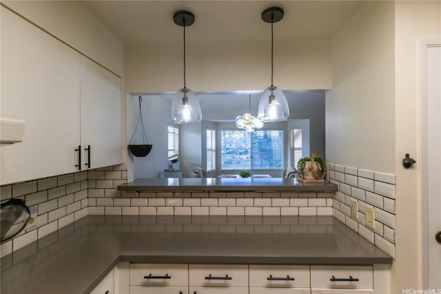 95-1058G Ainamakua Dr Unit 119, Mililani, HI 96789 - kitchen featuring dark countertops, backsplash, white cabinetry, and hanging light fixtures