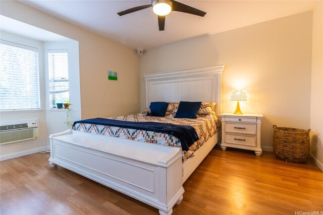 95-1058G Ainamakua Dr Unit 119, Mililani, HI 96789 - bedroom featuring an AC wall unit, wood finished floors, ceiling fan, and baseboards