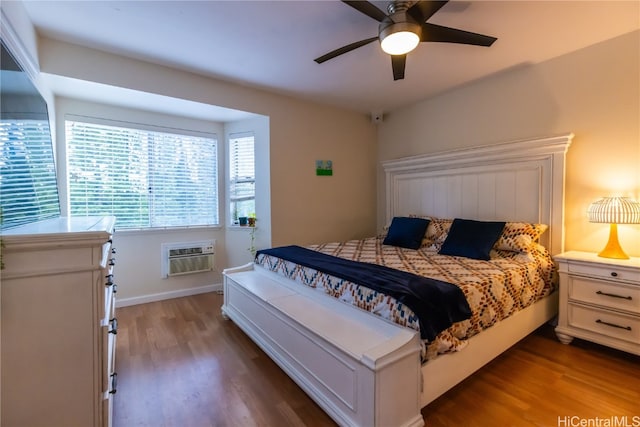 bedroom featuring a wall mounted AC, wood-type flooring, and ceiling fan