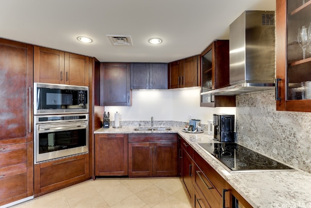 kitchen with wall chimney range hood, backsplash, light stone countertops, sink, and stainless steel appliances