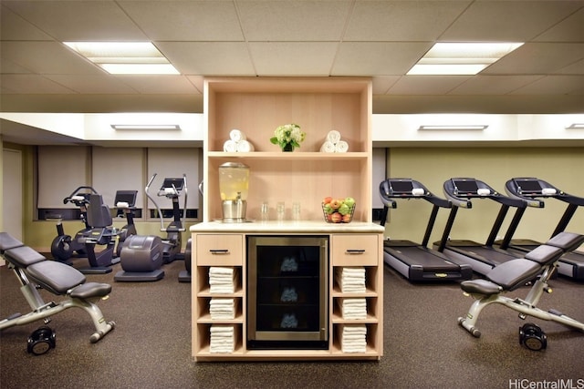 exercise room with a drop ceiling and indoor bar