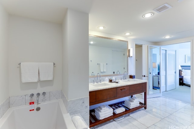 bathroom featuring vanity and a tub to relax in