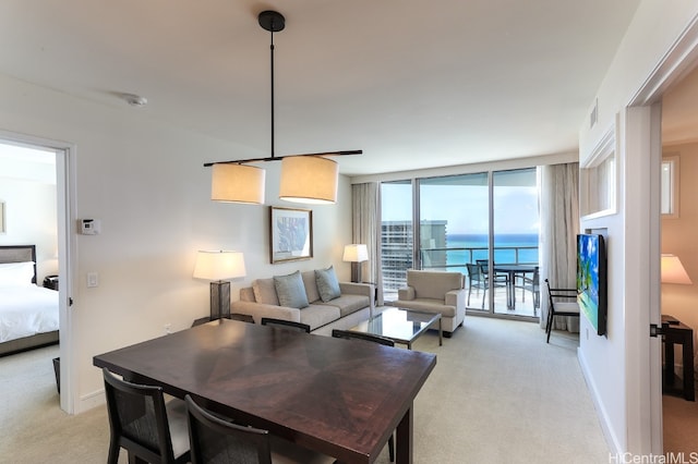 carpeted living room with a water view and a wall of windows