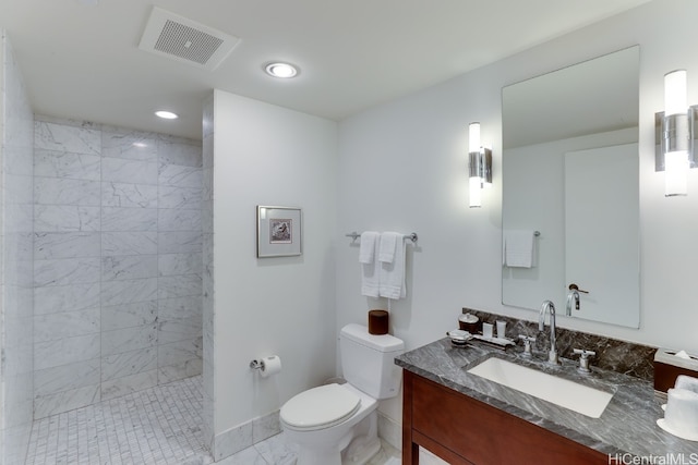 bathroom with vanity, a tile shower, and toilet