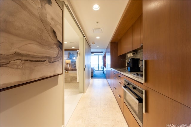 kitchen featuring cooktop, oven, and light tile patterned floors