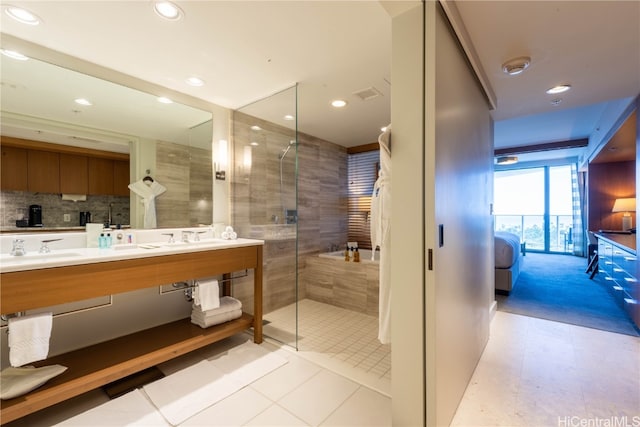 bathroom featuring vanity, backsplash, tile patterned floors, and a shower