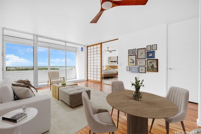 living room with light hardwood / wood-style floors and ceiling fan