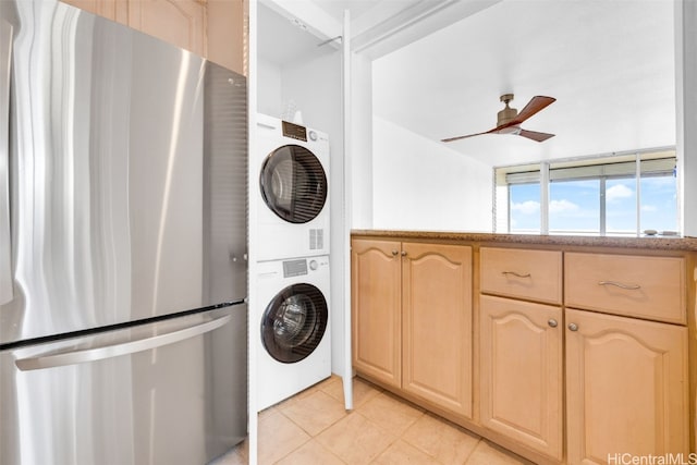 washroom with light tile patterned floors, ceiling fan, and stacked washer / dryer