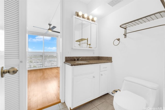 bathroom featuring vanity, hardwood / wood-style flooring, toilet, and ceiling fan