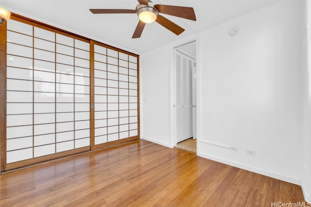 empty room with ceiling fan and light hardwood / wood-style flooring