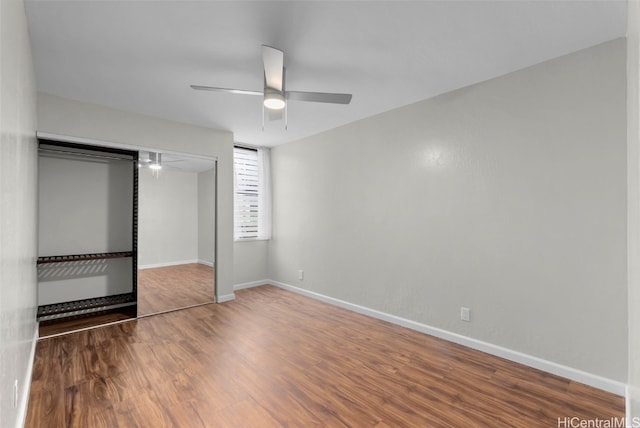 unfurnished bedroom with a closet, a ceiling fan, baseboards, and wood finished floors