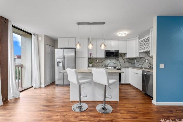 kitchen featuring pendant lighting, white cabinets, stainless steel appliances, and a kitchen island