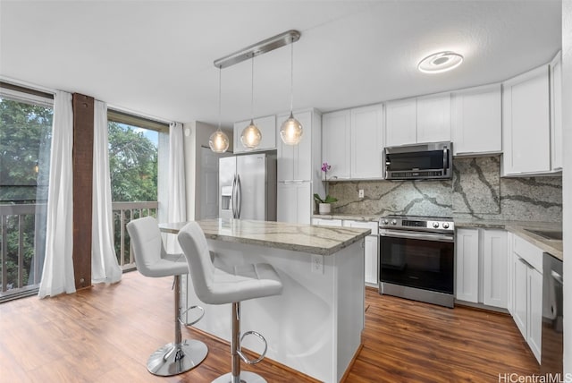 kitchen featuring white cabinetry, a center island, pendant lighting, and appliances with stainless steel finishes