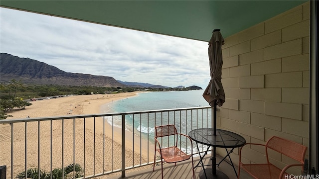 balcony featuring a view of the beach and a water and mountain view