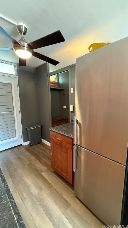 kitchen featuring stainless steel refrigerator, ceiling fan, and light wood-type flooring