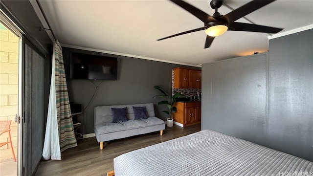 bedroom featuring dark wood-type flooring, ceiling fan, and ornamental molding