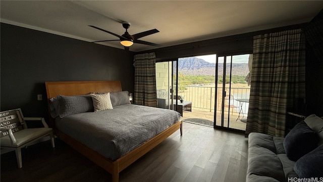 bedroom featuring a mountain view, ceiling fan, wood-type flooring, and access to outside