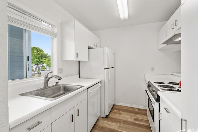 kitchen with white appliances, light hardwood / wood-style flooring, sink, and white cabinets