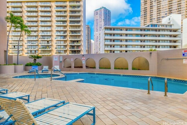 view of pool with a hot tub