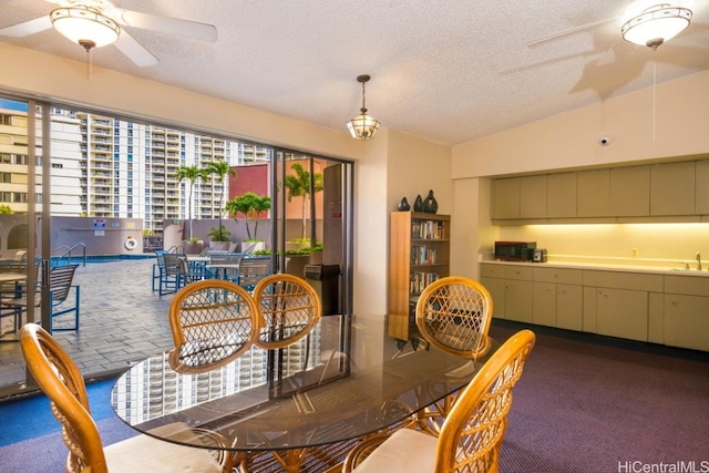 dining area featuring sink, a textured ceiling, carpet, and lofted ceiling