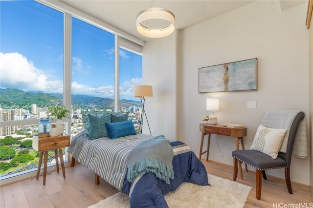 bedroom featuring a mountain view and hardwood / wood-style flooring