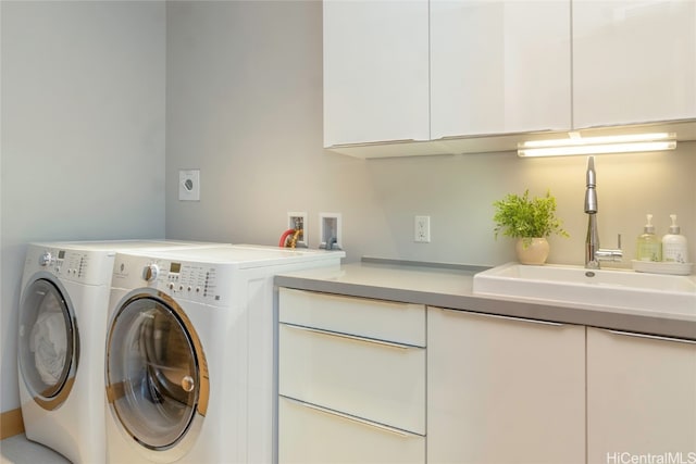 laundry area featuring cabinets, sink, and separate washer and dryer