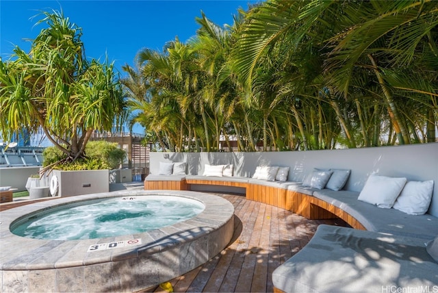 view of swimming pool featuring a deck and an in ground hot tub