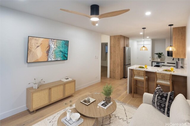 living room featuring ceiling fan and light hardwood / wood-style floors