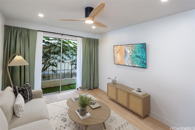 living room with ceiling fan and light hardwood / wood-style flooring