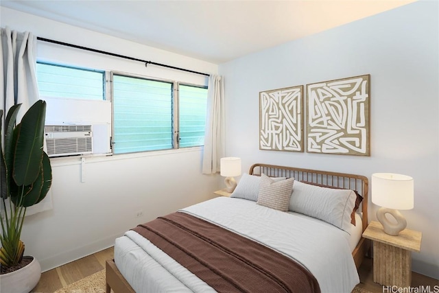 bedroom featuring cooling unit and wood finished floors