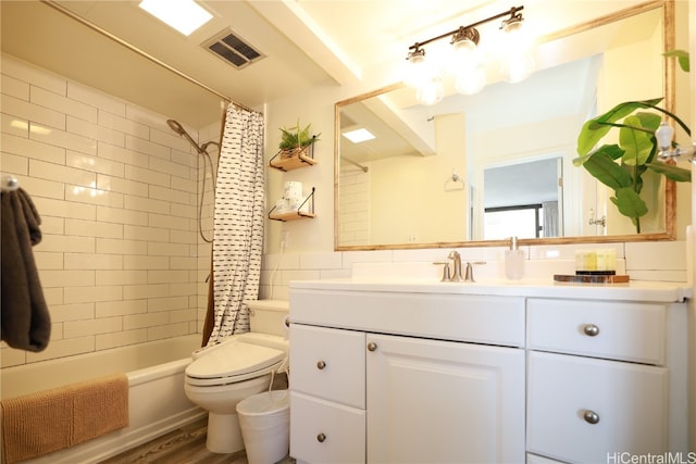 full bathroom with shower / bathtub combination with curtain, hardwood / wood-style floors, vanity, and toilet