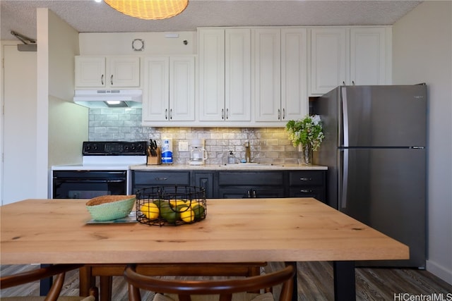 kitchen featuring white cabinets, sink, stainless steel fridge, tasteful backsplash, and white electric range oven