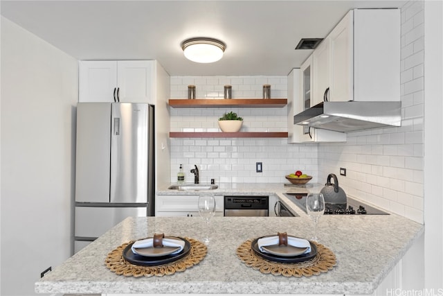 kitchen with tasteful backsplash, range hood, white cabinetry, appliances with stainless steel finishes, and sink