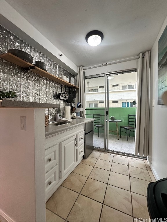 bar with white cabinetry, sink, black dishwasher, and light tile patterned flooring