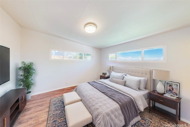 bedroom with hardwood / wood-style floors and lofted ceiling