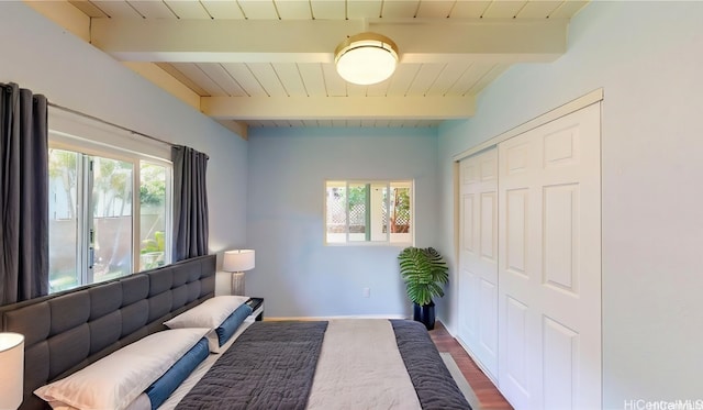 interior space featuring hardwood / wood-style flooring, multiple windows, beam ceiling, and wooden ceiling