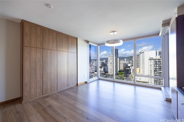 empty room with expansive windows and dark hardwood / wood-style floors