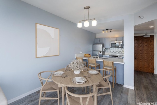 dining room with sink and dark hardwood / wood-style flooring