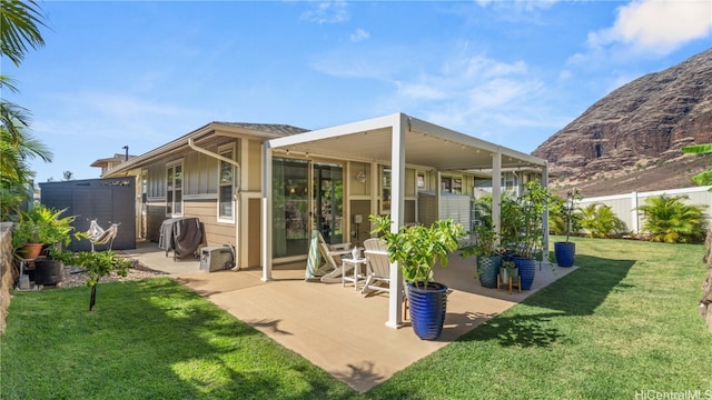 rear view of house featuring a patio and a yard