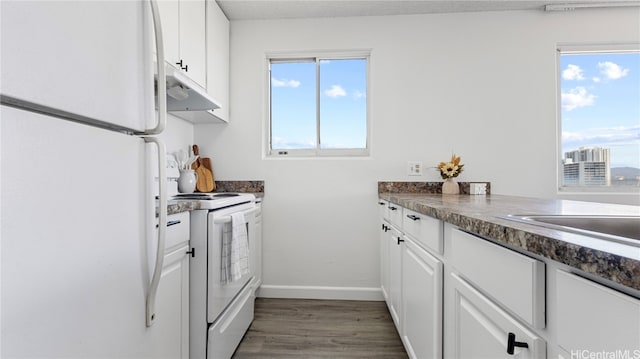 kitchen featuring a textured ceiling, white cabinetry, dark hardwood / wood-style floors, and white appliances