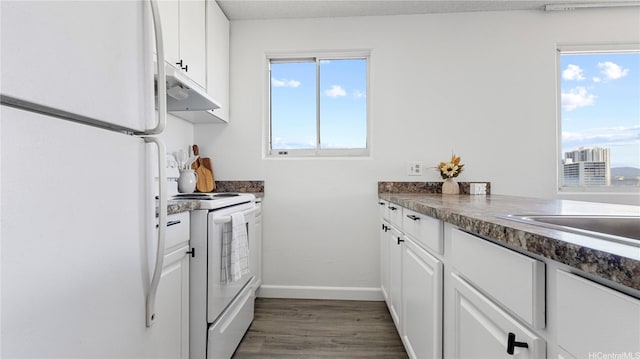 98-099 Uao Pl Unit 1501, Aiea, HI 96701 - kitchen with white appliances, under cabinet range hood, dark countertops, dark wood-type flooring, and white cabinetry