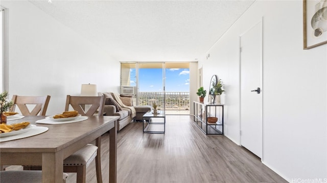 living room with a wall of windows, hardwood / wood-style flooring, and a textured ceiling