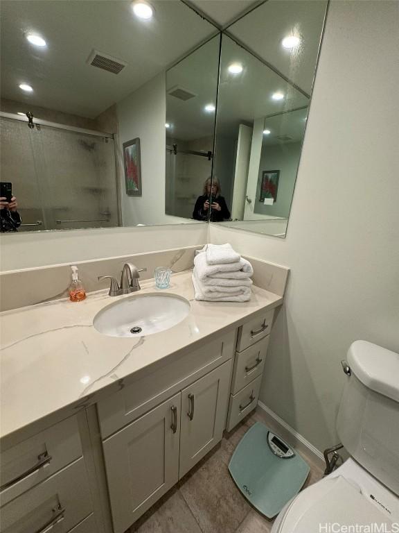 full bathroom with visible vents, vanity, toilet, and an enclosed shower