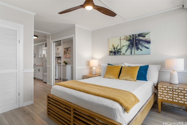 bedroom with ceiling fan, ensuite bathroom, light hardwood / wood-style floors, and ornamental molding