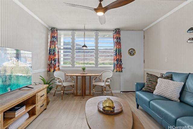 living room with ceiling fan, crown molding, and light hardwood / wood-style flooring