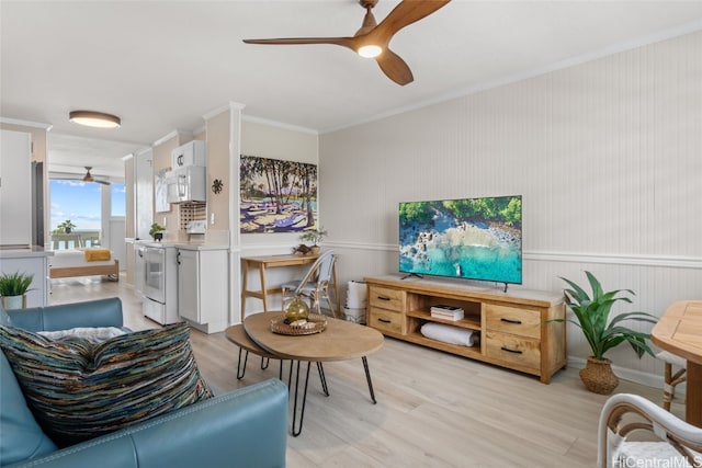 living room with light wood-type flooring, ceiling fan, and ornamental molding