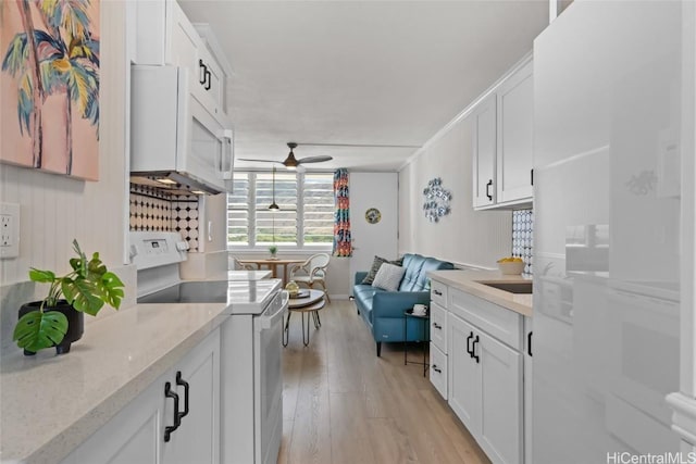 kitchen featuring ceiling fan, light stone countertops, white cabinets, and white range with electric cooktop